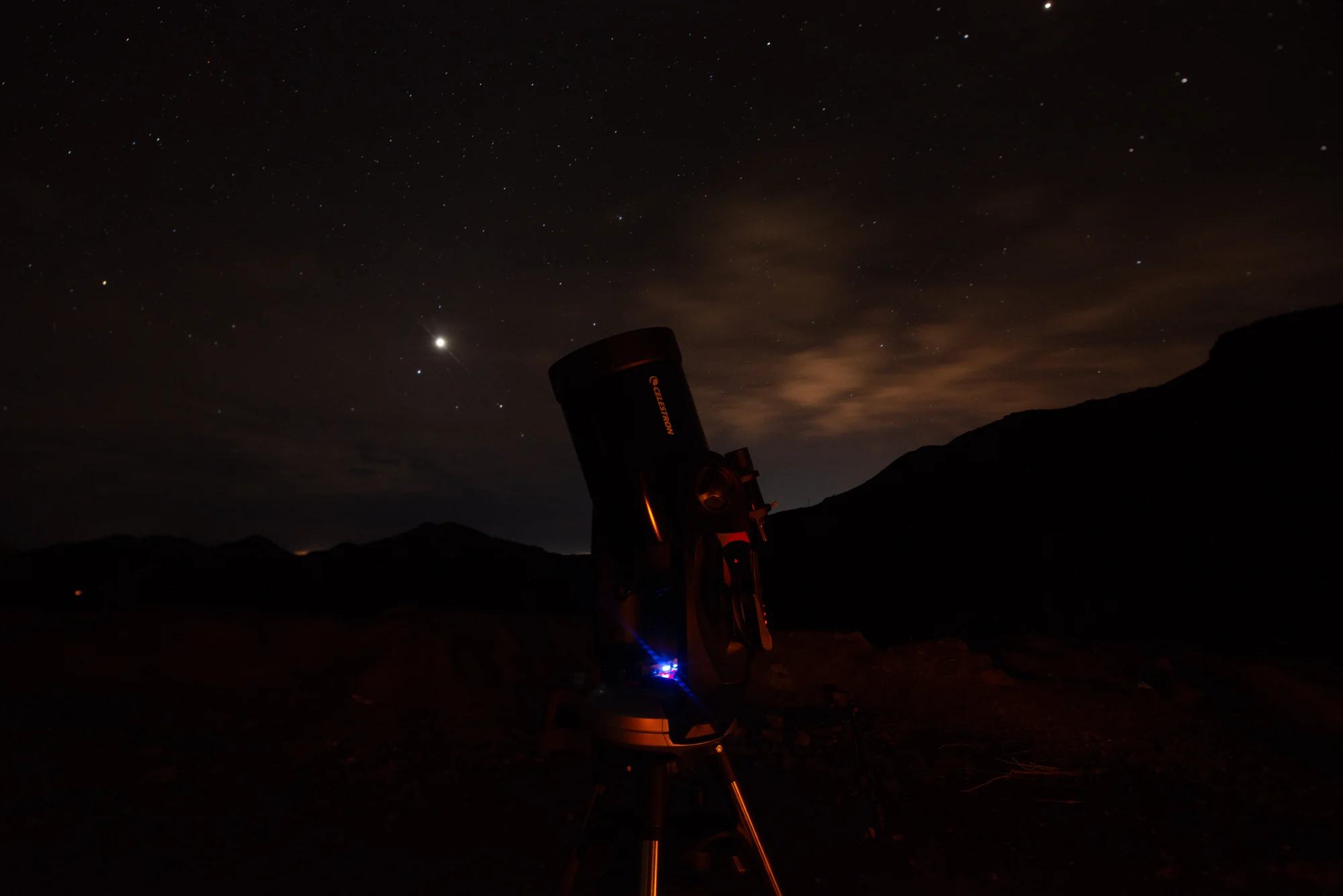 Cielo nocturno y silueta de un telescopio
